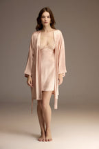Woman wearing a powder pink satin robe over a lace-trim slip nightgown — Belle Bonjour BM-1915