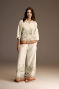 Woman wearing an ivory jacquard satin pajama set with bordeaux printed border — Belle Bonjour BM-1931
