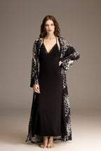Woman wearing a black printed viscose robe over a long black nightgown — Belle Bonjour BM-1967