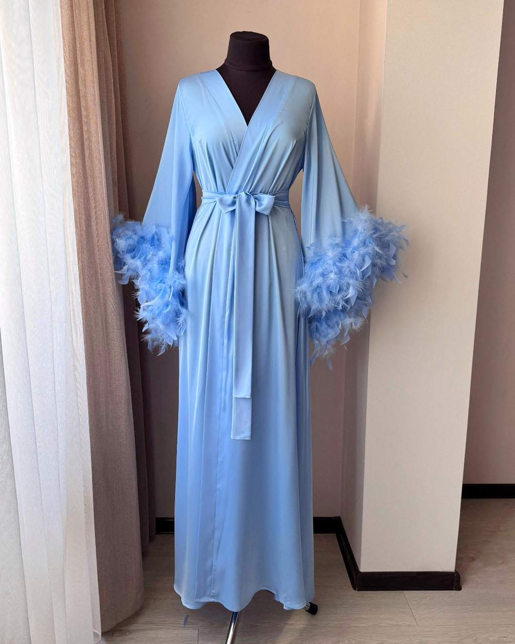 Light blue feather bridal robe by window